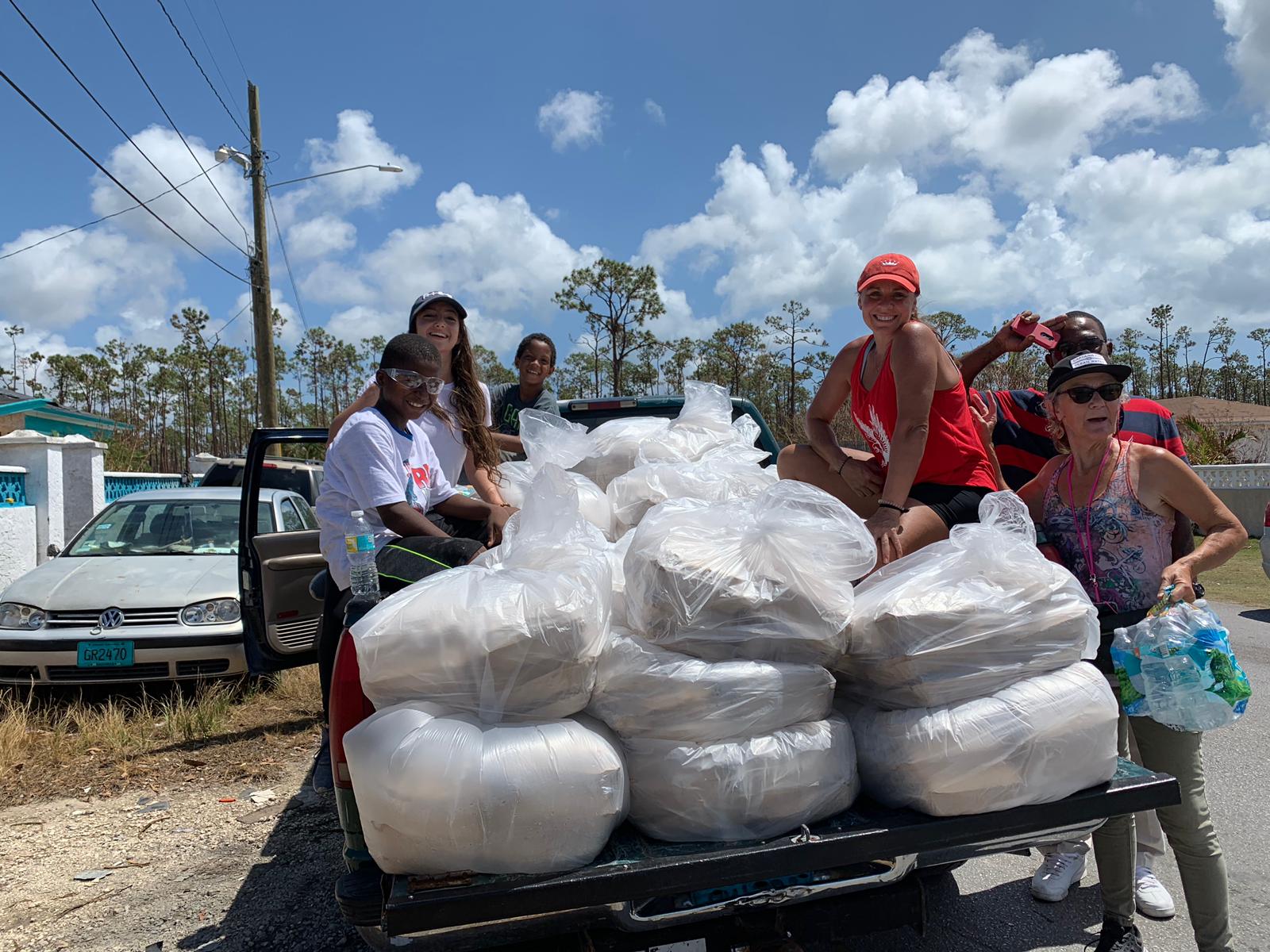 Volunteers On The Back Of Pickup Truck With Supplies